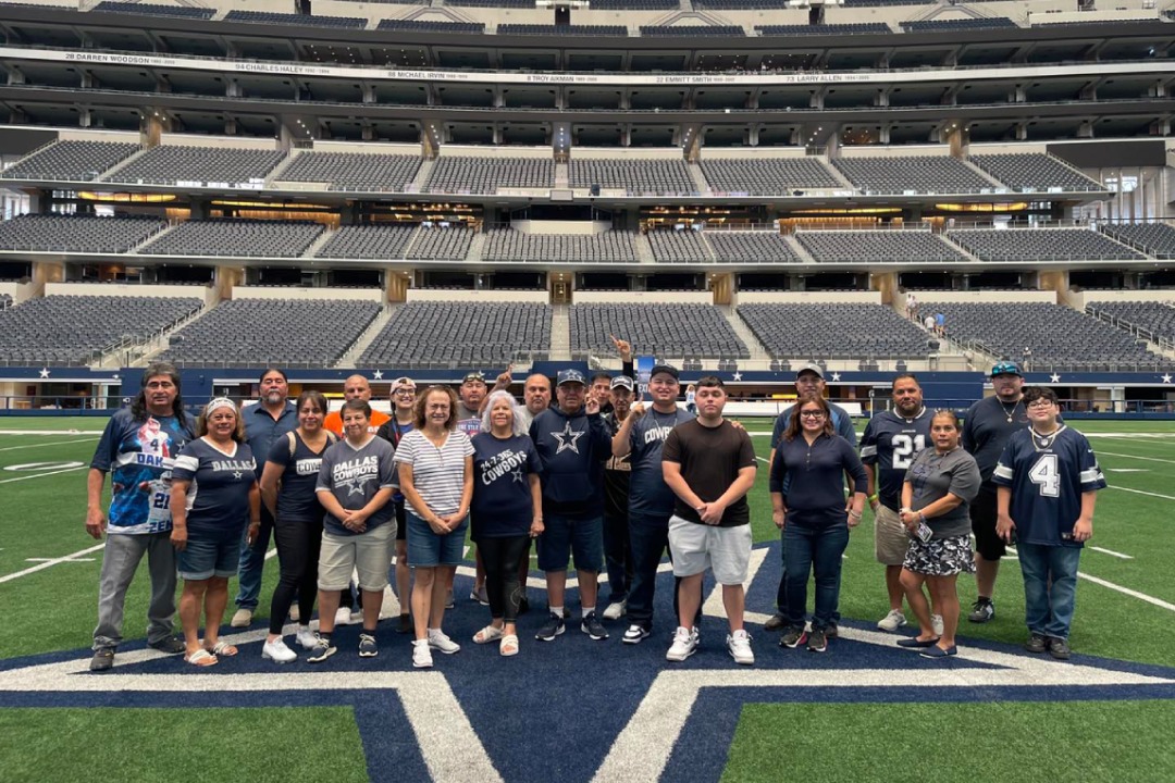 A group of people standing on a Dallas Cowboys football field
